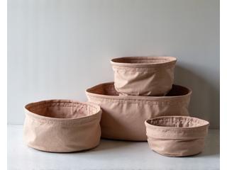 A collection of stylish, collapsible fabric storage bins neatly folded and stacked, ready for use or compact storage.