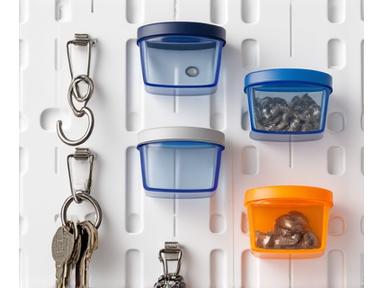 A variety of metal hooks and small plastic bins designed to clip onto modular pegboards, showcasing different sizes and shapes for holding tools, cords, and small parts.
